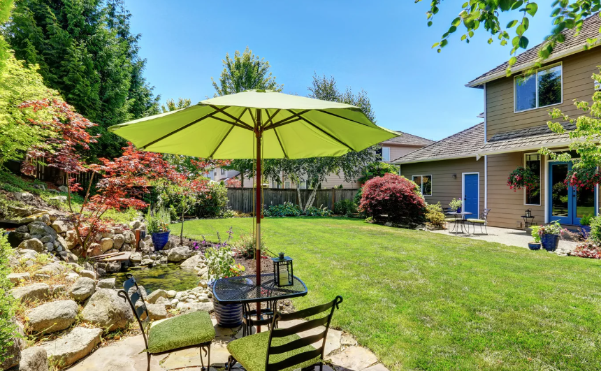 Beautiful summer residential landscaping Ontario with table and umbrella.